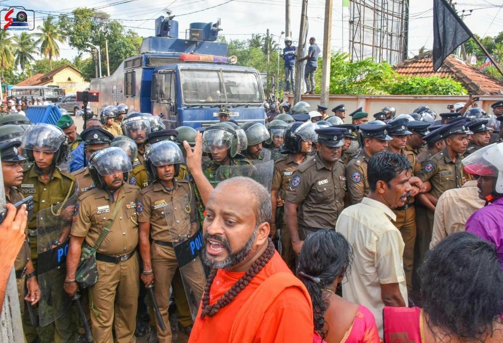 Tamil civil society leader Velan Swamigal surrounded by security forces during his arrest