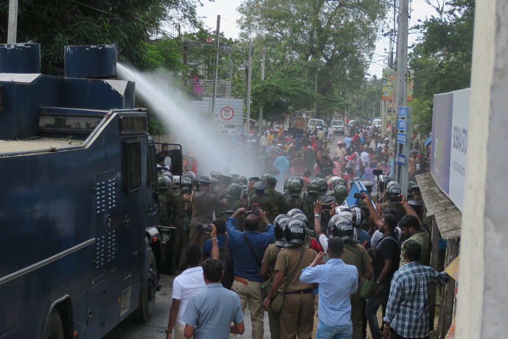 Sri Lankan security forces using water cannons against Tamil protesters during peaceful demonstrations in Jaffna